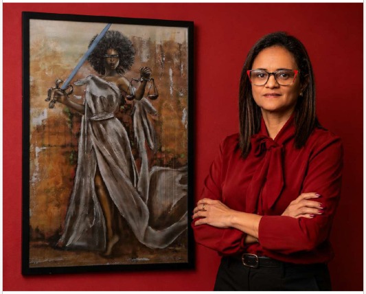 Dra. Ana Paula Moraes, advogada previdenciária em Porto Alegre, ao lado de quadro da Justiça